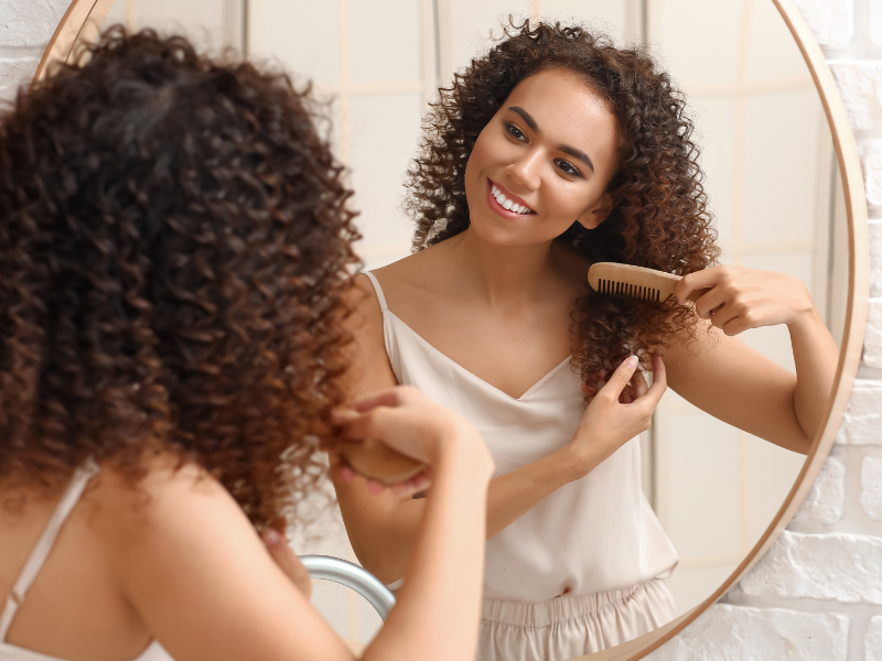 Mulher com cabelo cacheado, exibindo um estilo que celebra sua naturalidade e autenticidade, em harmonia com sua identidade interior.
